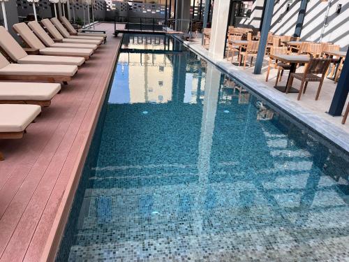 a swimming pool with chairs and tables on a building at Magnes Hotel in Volos