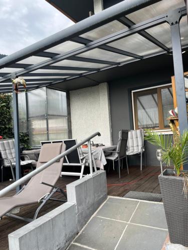 a patio with chairs and tables on a deck at Pension Lärchenhof in Döbriach