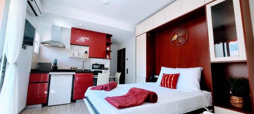 - une chambre avec des armoires rouges et un lit blanc avec des oreillers rouges dans l'établissement Rêve Azur studio 6 à deux pas de la mer Parking wifi, à Cagnes-sur-Mer