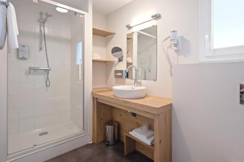 a bathroom with a sink and a shower at Kyriad Vannes Centre Ville in Vannes