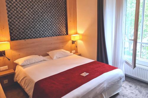 a bedroom with a large bed with a red blanket at Kyriad Vannes Centre Ville in Vannes