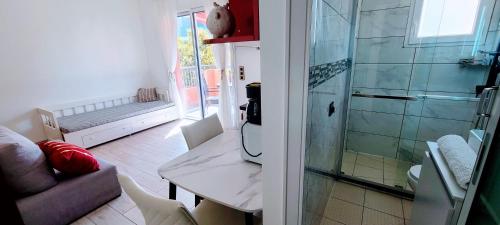La salle de bains est pourvue d'une douche, d'une table et de chaises. dans l'établissement Rêve Azur studio 6 à deux pas de la mer Parking wifi, à Cagnes-sur-Mer
