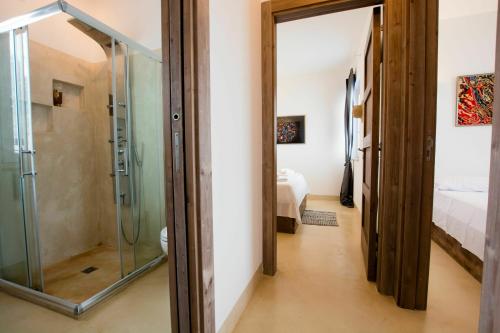 カロヴィーニョにあるVilla Butterfly by Raro Villasのベッドルーム1室付きの客室で、ガラス張りのシャワーが備わります。