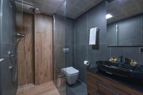 a bathroom with a black sink and a toilet at İSTPORT GARDEN HOTELS in Arnavutköy