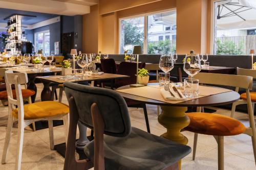 a restaurant with tables and chairs with wine glasses at Adesso Hotel in Rome