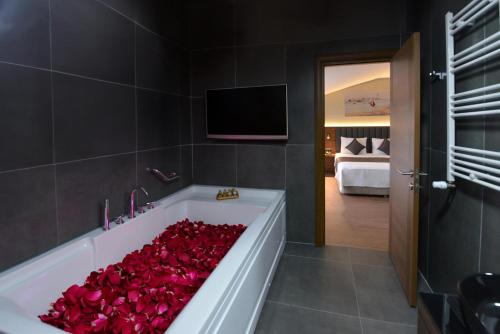 une salle de bains avec une baignoire remplie de roses rouges dans l'établissement İSTPORT GARDEN HOTELS, à Arnavutköy