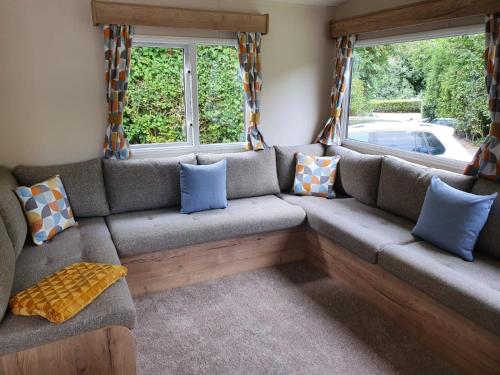 a couch in a living room with pillows on it at 24 Chestnut Grove Caravan in Humberston