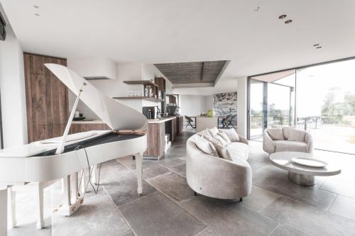 sala de estar con piano y sofá en B&B Au Porte Bonheur, en Zwalm
