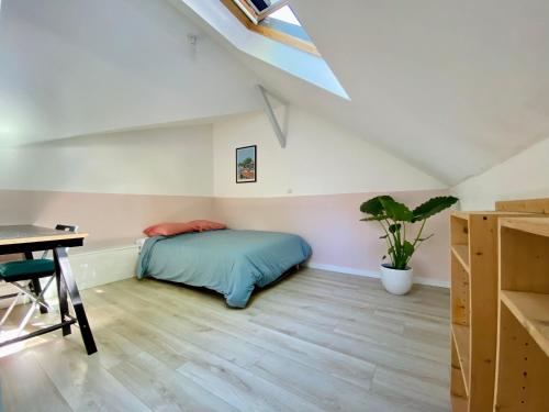 - une chambre mansardée avec un lit et un bureau dans l'établissement Casa Pelican, à Nantes