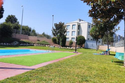 a park with a swimming pool and a building at Piso en Rías Bajas con piscina RIANXO in Rianjo