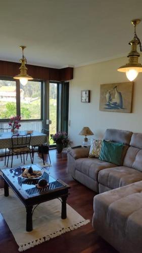 a living room with a couch and a table at Piso en Rías Bajas con piscina RIANXO in Rianjo