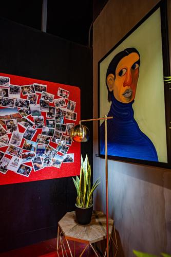 a painting of a man on a wall next to a lamp at HeSu Hidden Art Hotel & Suites - Near Bell Tower & Ideal Location-Spacious rooms featuring King or Double Queen beds -Exclusive Two&Three-Bedroom Suites with Expansive Living Rooms for Group Gathering-Kitty Cuddles & Coffee Gift -Seamless Journey Planning in Xi'an
