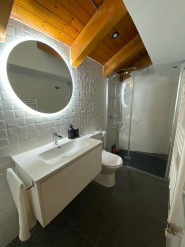 a bathroom with a sink and a mirror and a toilet at Duplex Kasares en Sesué No VU HUESCA24037 in Sesué