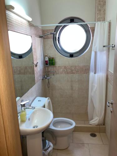 a bathroom with a toilet and a sink and a window at Lamia central luxury apartment in Lamía