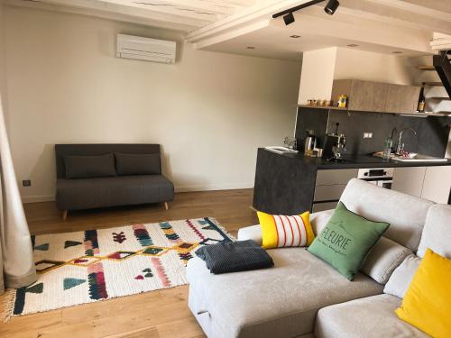 a living room with a couch and a kitchen at Bulles en Beaujolais Spa & Sauna in Fleurie