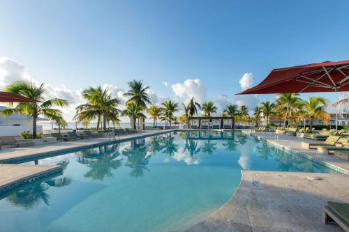 a large swimming pool with palm trees in a resort at Viva Fortuna Beach by Wyndham, A Trademark All Inclusive in Freeport