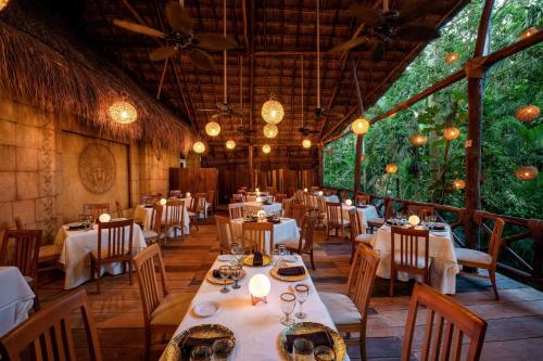 a dining room with tables and chairs and lights at Viva Azteca by Wyndham, A Trademark All Inclusive Resort in Playa del Carmen