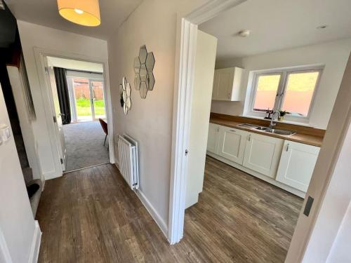 a kitchen with white cabinets and a wooden floor at Luxury Newly Renovated House 