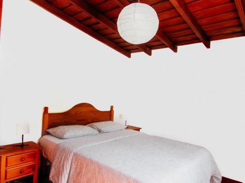 een slaapkamer met een wit bed en een houten plafond bij La Bodega casa rural con piscina y jardines in Breña Baja