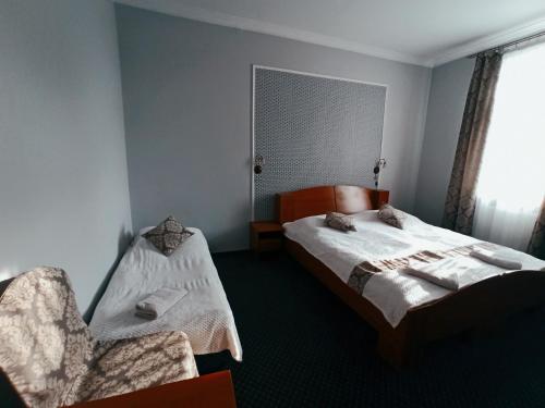 1 dormitorio con 1 cama y 1 silla en Pokoje Gościnne Kropka en Tarnowskie Góry