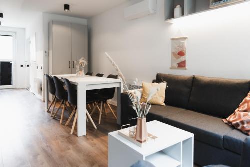 een woonkamer met een bank en een tafel bij Neue stylische HÜSLE by UNIQUE PLACES in Bludenz