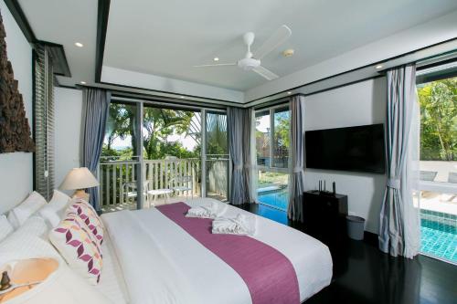 a bedroom with a bed and a tv and a pool at Katamanda Villa Mila A1 near Kata Beach in Kata Beach