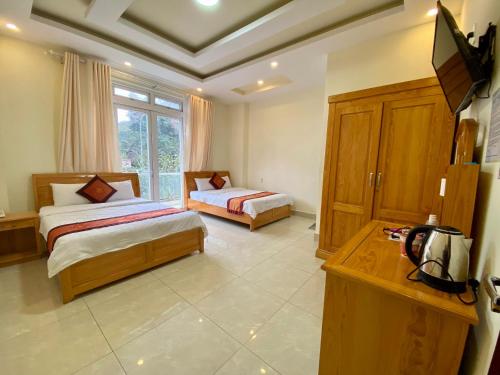 een slaapkamer met 2 bedden en een groot raam bij Khách sạn Hải Hoa Đà Lạt in Da Lat