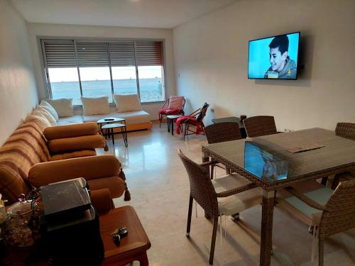 a living room with a couch and a table at Appartement pied dans l'eau in Imi Ouaddar