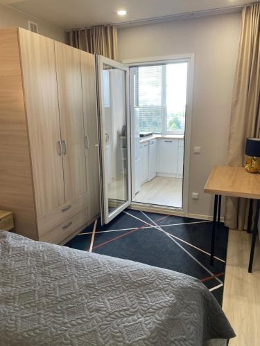 um quarto com uma cama e uma porta de vidro deslizante em Like at home Daumani em Narva