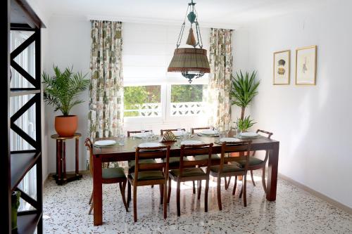una sala da pranzo con tavolo e sedie di Newly furnished cozy house next to the beach a Calafell