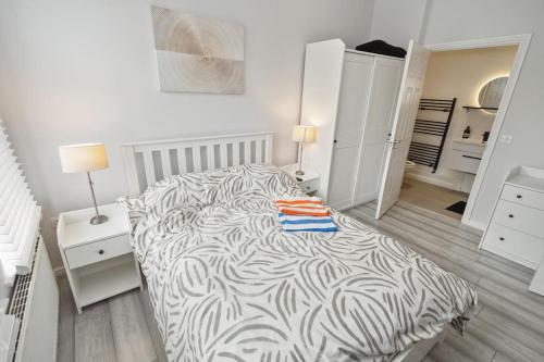 a white bedroom with a zebra print bed and two lamps at Modern Watford Urban Luxury Oasis in Leavesden Green
