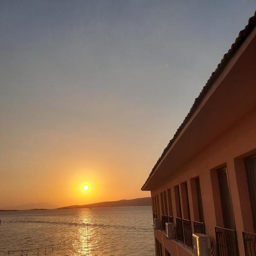 a sunset over the water next to a building at CasaLyma Ayvalık in Ayvalık