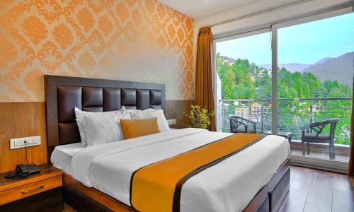 a bedroom with a large bed and a large window at Dalhousie View Resort in Dalhousie