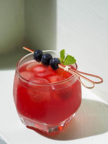 a glass of red drink with blueberries and mint at PS23 Residence in Hat Yai