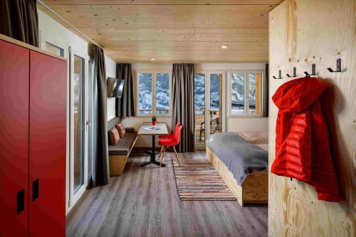 ein Schlafzimmer mit einem Bett und einem Schreibtisch in einem Zimmer in der Unterkunft Eiger Guesthouse in Mürren