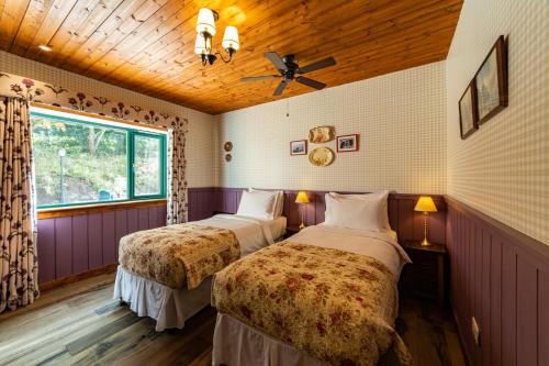 a bedroom with two beds and a ceiling fan at Black Sheep Hotels Cabins in Spean Bridge