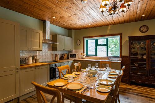 a kitchen with a wooden table and a dining room at Black Sheep Hotels Cabins in Spean Bridge