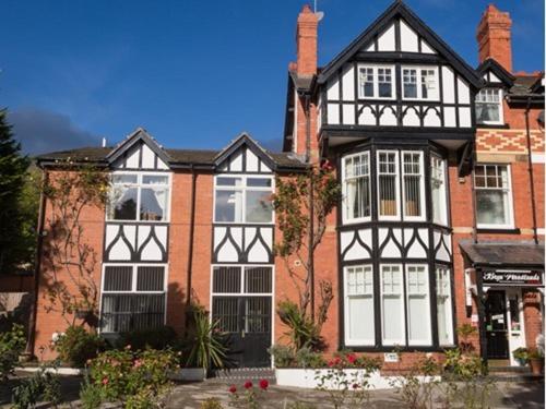 a large house with black and white windows at Bryn Woodlands House in Colwyn Bay