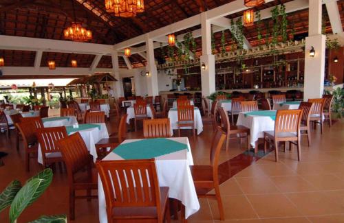 un restaurante con mesas y sillas y un bar en Saigon Emerald Beach Resort en Mui Ne