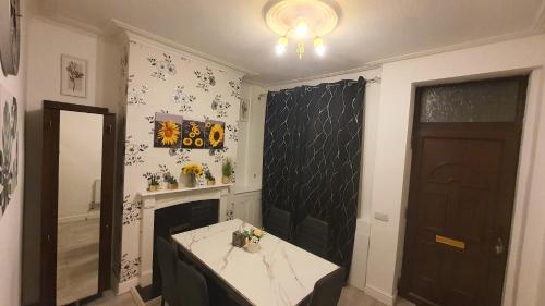 a room with a table and a fireplace and a door at 2 bedroom house, Tunstall, Stoke-on-Trent. in Stoke on Trent