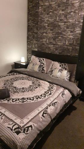 a bed in a bedroom with a brick wall at 2 bedroom house, Tunstall, Stoke-on-Trent. in Stoke on Trent