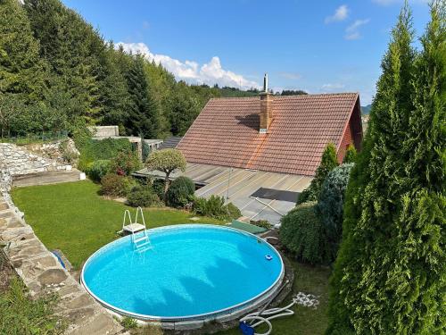 a swimming pool in a yard next to a house at Ubytovanie Privat Antoni - apartmán v RD in Tvrdošín