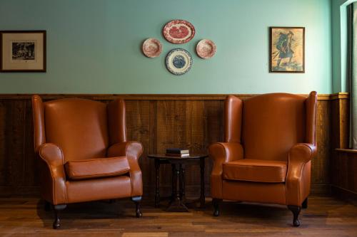 two leather chairs and a table in a waiting room at Black Sheep Hotels Cabins in Spean Bridge