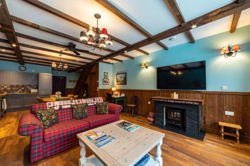 a living room with a couch and a fireplace at Black Sheep Hotels Cabins in Spean Bridge