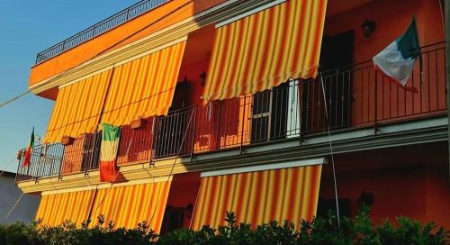 an orange building with flags on the side of it at Acerra's Villa in Nola