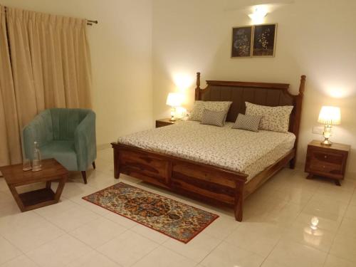 Luxre Homes - Villa in Koramangala في بانغالور: غرفة نوم بسرير وكرسي ازرق