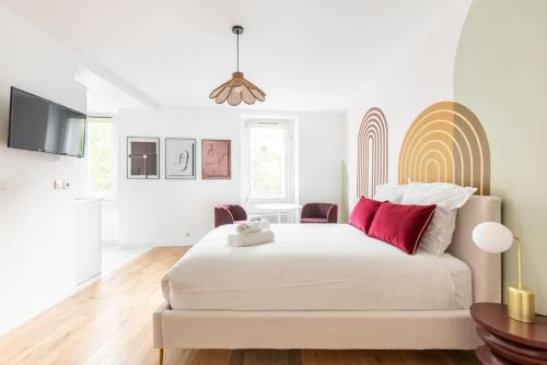 - une chambre blanche avec un grand lit blanc et des oreillers rouges dans l'établissement Studio Place de la Nation - 2GG - II, à Paris