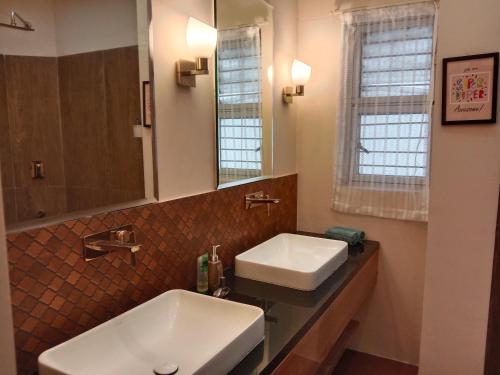 a bathroom with two sinks and a mirror at Luxre Homes - Villa in Koramangala in Bangalore