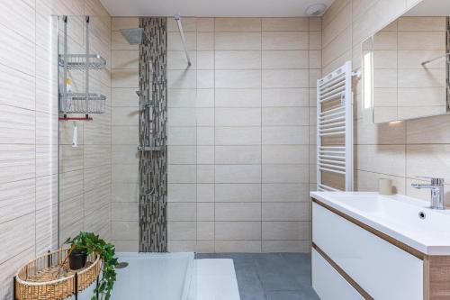 a bathroom with a sink and a toilet and a tub at La p'tite maison de Charlotte in Cissac-Médoc