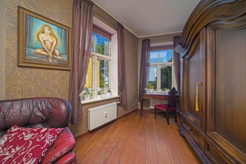 a living room with a couch and a table and windows at Apartment With a Lake View and Sauna in Viljandi